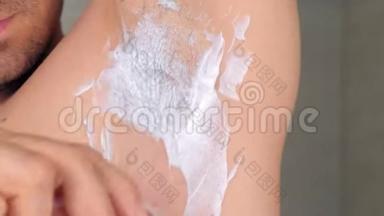男人剃须腋窝<strong>脱毛膏</strong>使用刮刀在淋浴，特写视图。